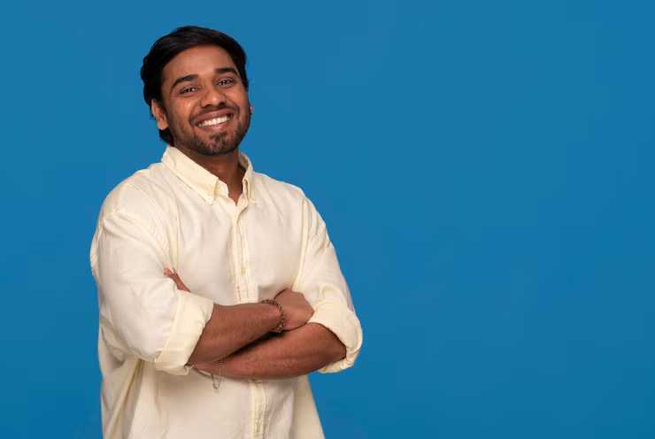 smiling man in yellow shirt on blue background